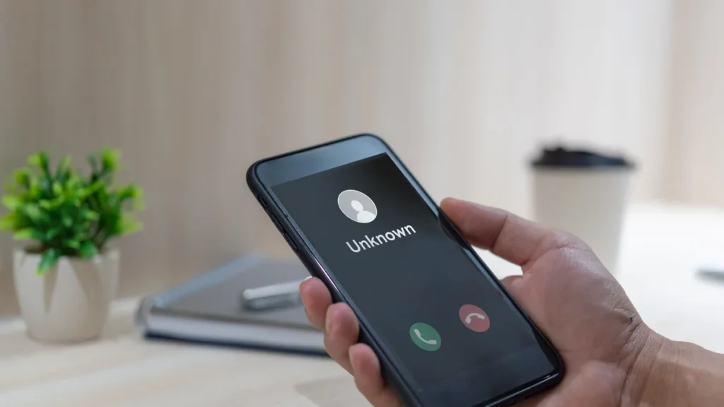 Smartphone affichant un appel entrant d’un numéro inconnu, à identifier avec un annuaire inversé
